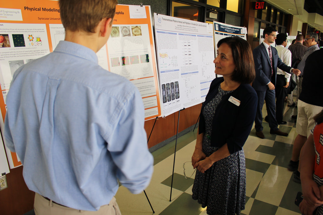 High school intern Luke Rath explains his poster to Dean Teresa A. Dahlberg, 2017.