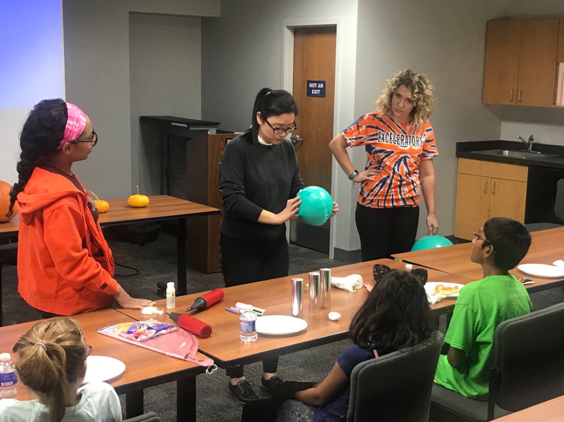 Group members run hands-on balloon-wrinkling demos for kids at Manlius Library, 2018.